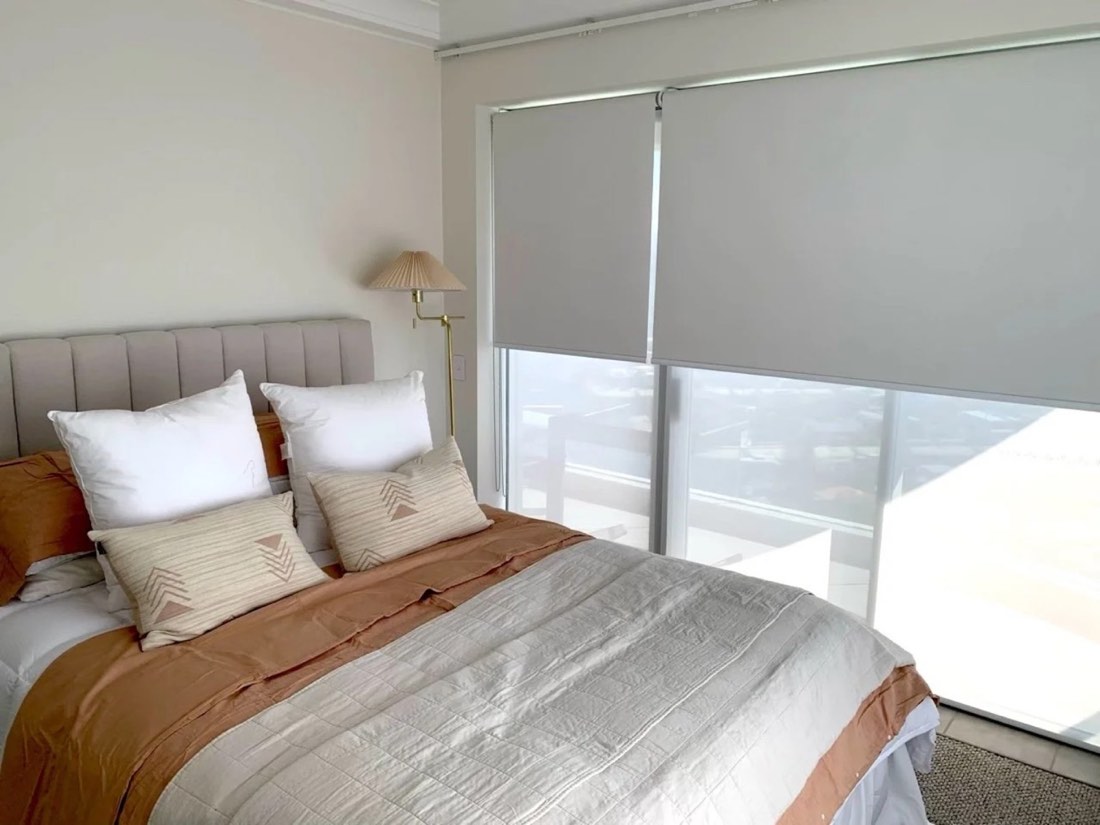 Double roller blinds installed in a bright bedroom