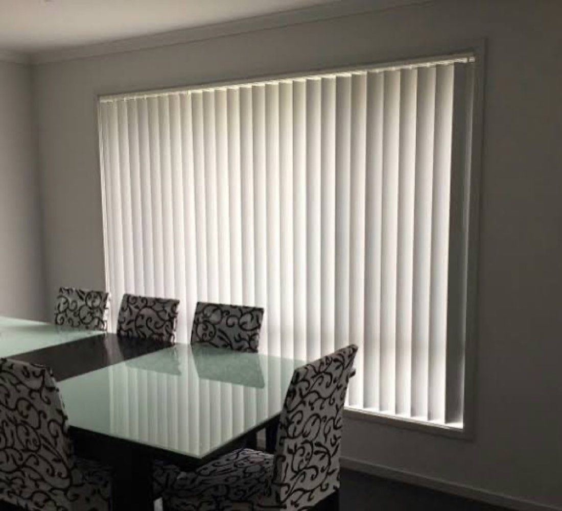 White vertical blinds installed in a dining room