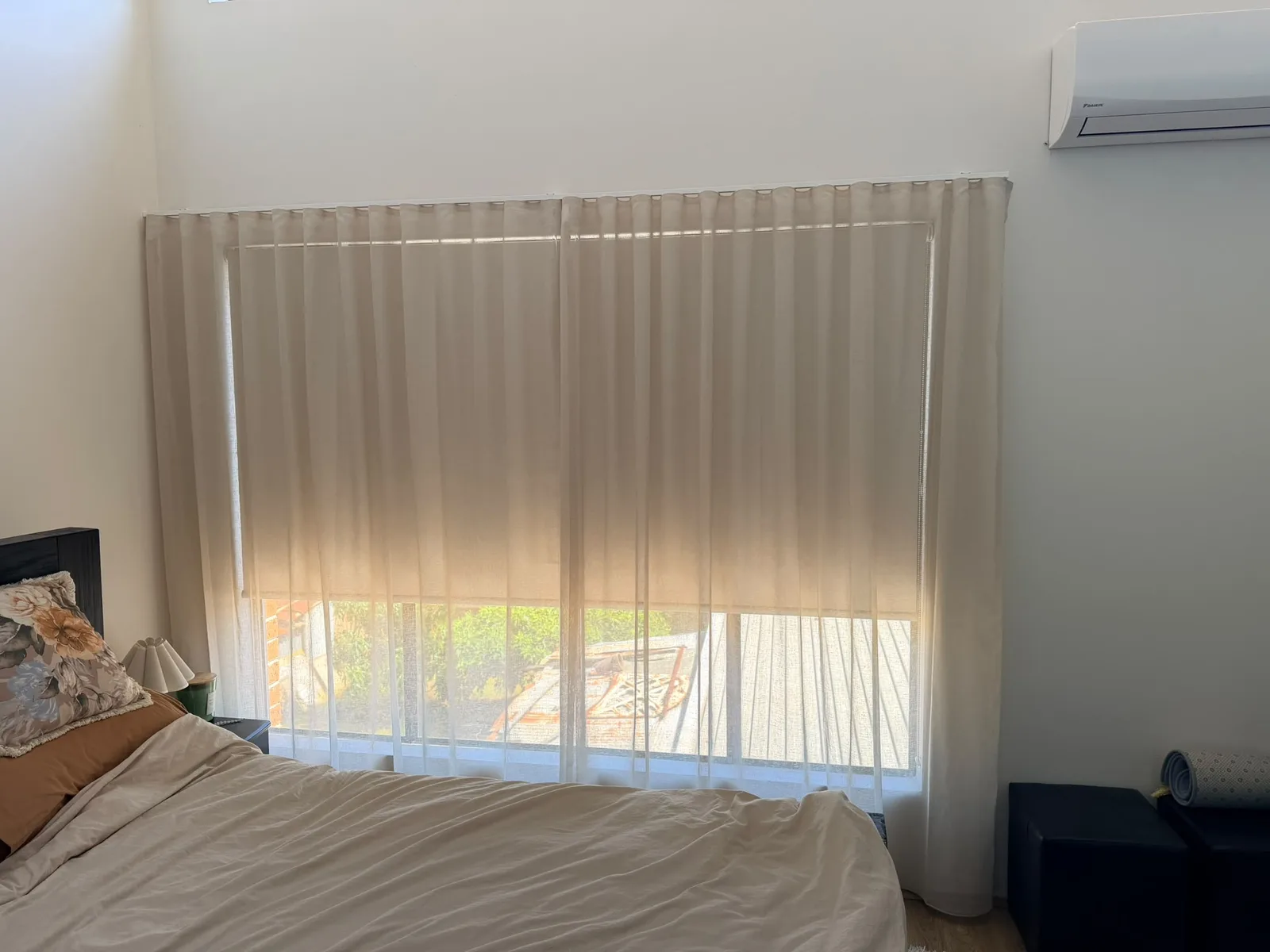Sheer curtains over a blockout roller blind on a bedroom window in Punchbowl