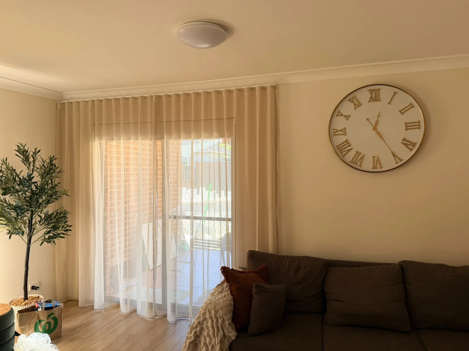 Sheer wave curtains in Driftwood across a living room sliding door in Punchbowl